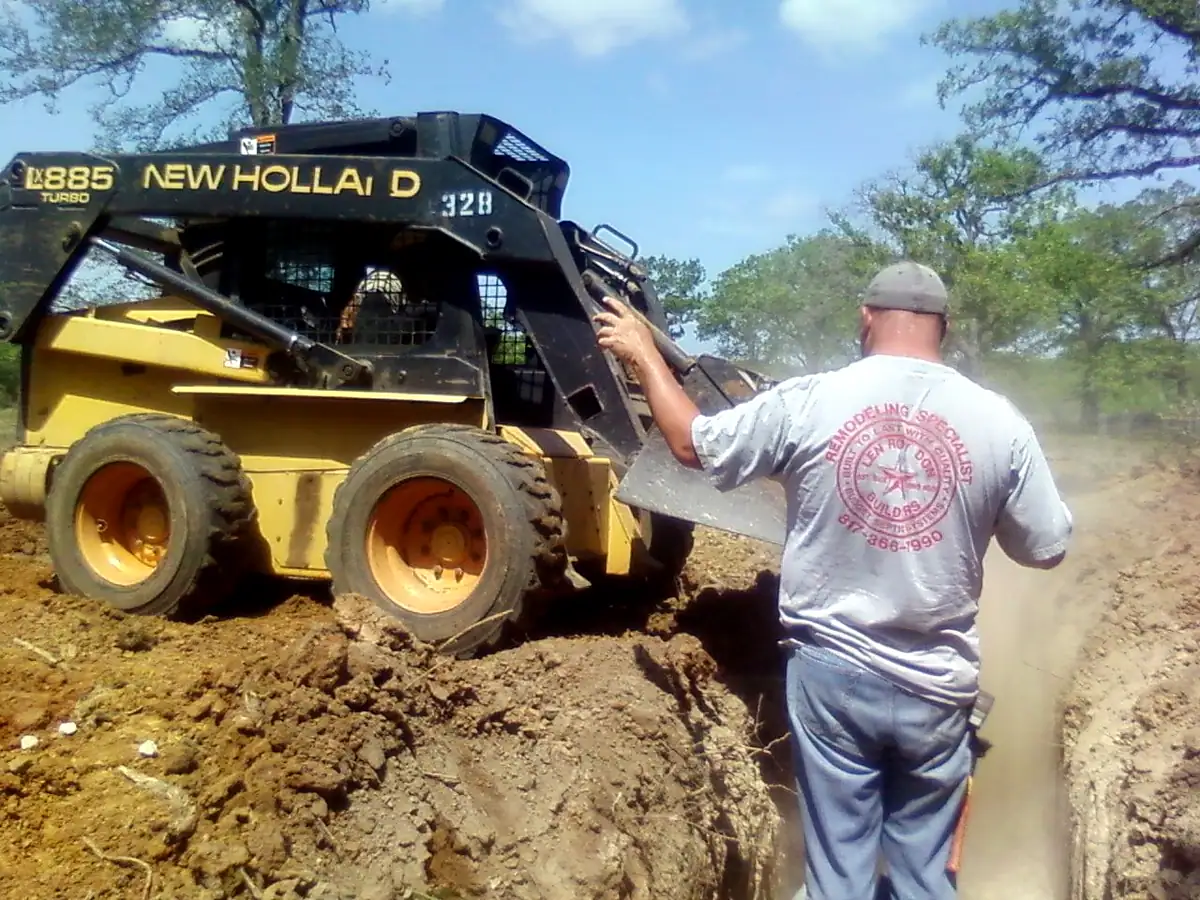 Skid steer digging lateral lines for a new septic field