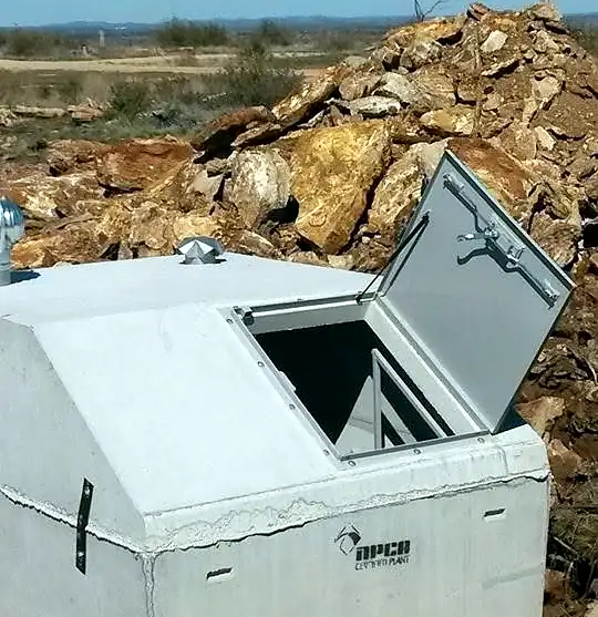 Slope-front concrete storm shelter installed in a yard